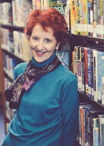 Author Kathleen Irene Paterka stnading near a bookshelf